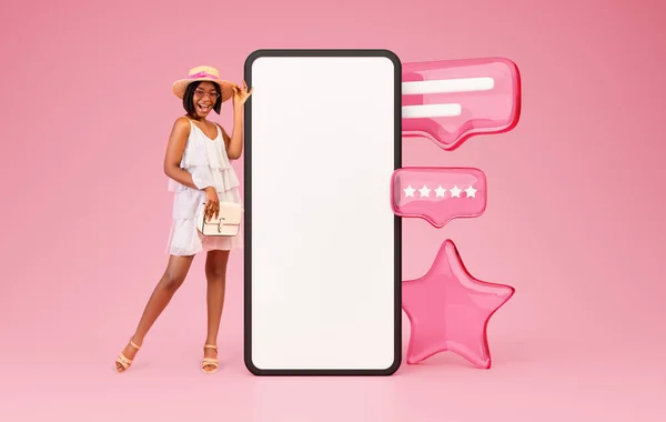 Best Shopping App. Excited Black Woman Customer Posing Near Huge Smartphone Screen Standing Over Pink Background In Studio. Collage With Big Stars And Rating Message Icons. Mockup