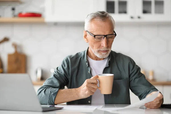 Uomo Anziano Che Lavora Con Documenti Laptop Cucina Beve Caffè — Foto Stock