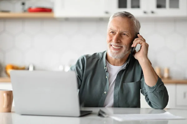 Happy Senior Man Μιλώντας Στο Κινητό Τηλέφωνο Και Χρησιμοποιώντας Φορητό — Φωτογραφία Αρχείου