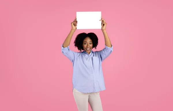 笑着年轻的怀孕的非洲卷曲女士在休闲与大腹部举行空格横幅 孤立在粉红工作室的背景 广告和服务 — 图库照片