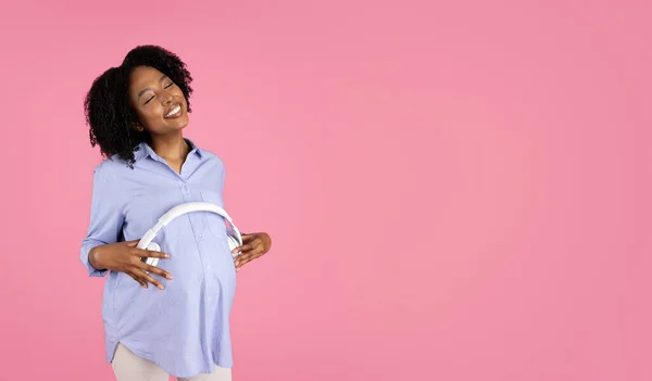 Mujer Rizada Afroamericana Embarazada Joven Satisfecha Casuales Pone Auriculares Gran — Foto de Stock