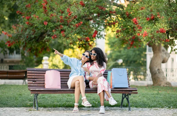 Две Счастливые Многоэтнические Женщины Подруги Отдыхают Скамейке После Шоппинга Веселые — стоковое фото