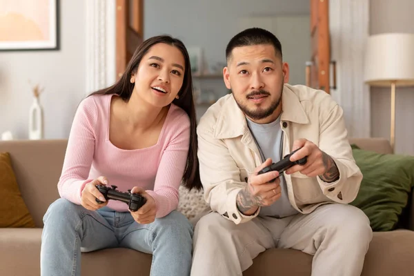 아시아 커플들 집에서 소파에 비디오 게임을 즐기는 한국의 아내는 주말에 — 스톡 사진