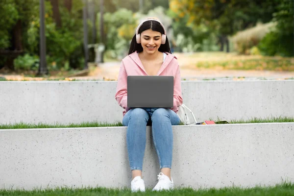Szczęśliwa Studentka Nastolatki Słuchawkach Bezprzewodowych Korzystająca Laptopa Studiująca Kampusie Uniwersyteckim — Zdjęcie stockowe