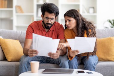 Kederli genç Hintli çift, mali krizden muzdarip. Evlerinde evrakları kontrol ediyorlar, Milenyum Doğu eşleri koltukta oturuyor ve kredi belgelerini okuyor, vergi sayıyor ve aile bütçesini planlıyorlar.