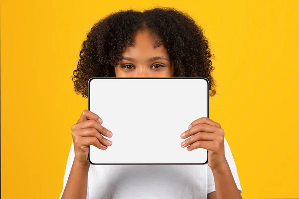 쾌활하게 구부정 여학생 티셔츠를 노란색 스튜디오에 스크린 태블릿을 사이트 — 스톡 사진