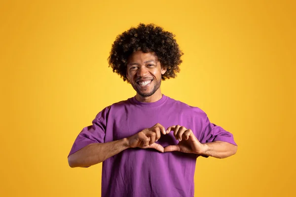 Веселый Черный Взрослый Кудрявый Мужчина Фиолетовой Футболке Делает Сердечный Жест — стоковое фото