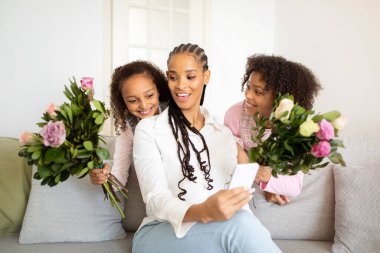 Aile Aşkı. Mutlu Afro-Amerikan Kızları, annelerinin doğum gününde çiçeklerini sunar. Çocuklar tatilde annelerini tebrik ediyor. Özel Gün Kutlama Kavramı
