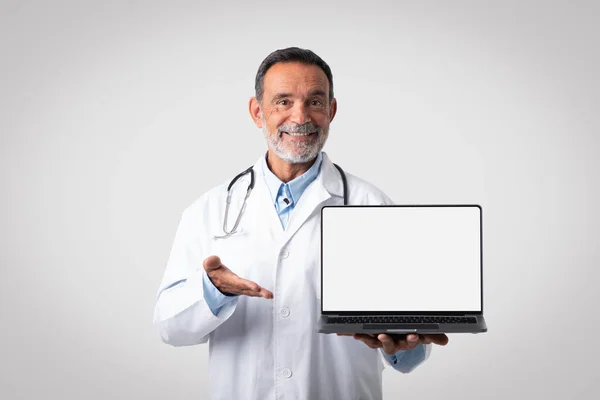 Szczęśliwy Biały Dojrzały Mężczyzna Lekarz Białym Płaszczu Punkt Ręka Laptopie — Zdjęcie stockowe