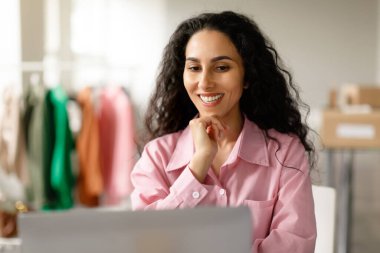 Dijital Moda Dünyası. İnternette çalışan neşeli girişimci bayan giysi mağazasında bilgisayarın başında oturuyor. Moda Şov Salonu Sahipliği, Perakende ve Ticaret Başarı Konsepti