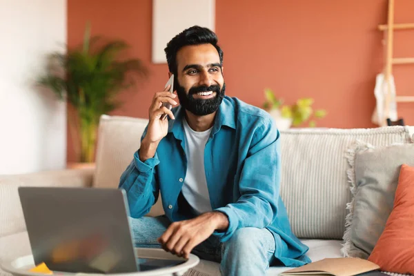 Mobiel Aanbod Vrolijke Indiaanse Man Met Laptop Aan Telefoon Zittend — Stockfoto