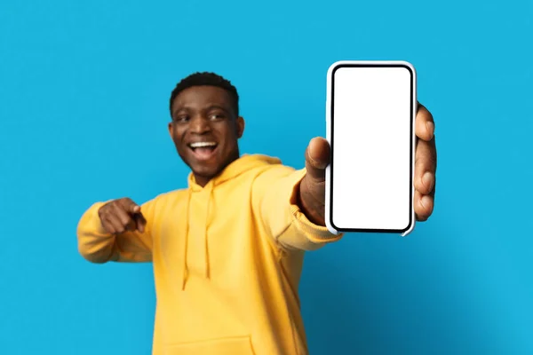 在线报价 大款现代手机 白色的空屏幕 手握快乐英俊的非洲裔美国人的手 黑人手握着装有笑柄的智能手机 与蓝色背景隔离 — 图库照片