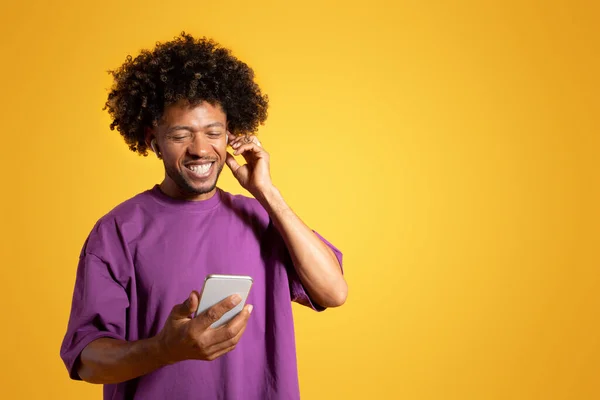 Vrolijke Zwarte Volwassen Krullende Man Paars Shirt Draadloze Hoofdtelefoon Kijkt — Stockfoto
