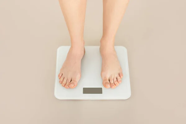 電子床スケールの女性の足は ベージュのスタジオの背景に撮影クロップ 認識できない女性は彼女の体重をチェックし 現代的な食事 健康的なデトックス 運動の結果を監視します — ストック写真