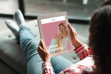 Ekranda moda mağazası olan dijital tablet kullanan genç bir bayan giysi siparişi veriyor, mobil uygulama evde, yakın çekim. Çevrimiçi alışveriş uygulaması, müşteri web sitesi, teslimat alımları