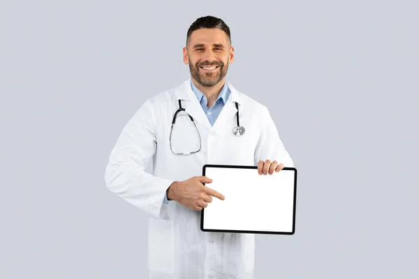Χαρούμενος Μεσήλικας Γιατρός Που Δείχνει Δάχτυλο Tablet Λευκή Οθόνη Πάνω — Φωτογραφία Αρχείου
