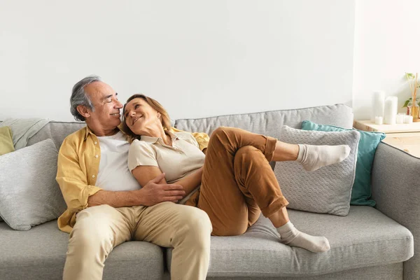 浪漫的爱情快乐的欧洲老人夫妇拥抱着坐在沙发上 享受着在家里度过的时光 浪漫与感情的概念 — 图库照片