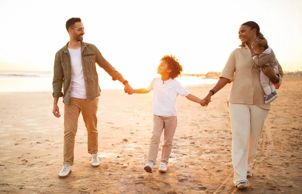 Wielorasowi Rodzice Spacerujący Plaży Dwoma Synami Trzymający Się Ręce Uśmiechnięci — Zdjęcie stockowe