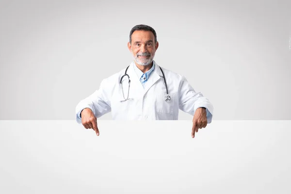 Terapeuta Médico Sênior Caucasiano Positivo Casaco Branco Aponta Dedos Banner — Fotografia de Stock