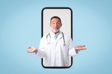 Beyaz önlüklü mutlu Kafkas doktor terapisti büyük telefon ekranında boş bir yer tutuyor, mavi arka planda, stüdyoda izole edilmiş. Tıbbi hizmet seçimi, sağlık hizmetleri