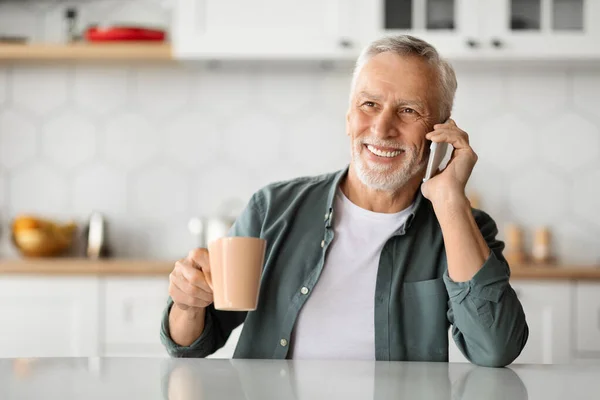 Boldog Senior Man Beszél Mobiltelefon Kávézás Konyhában Mosolygó Idősebb Úriember — Stock Fotó