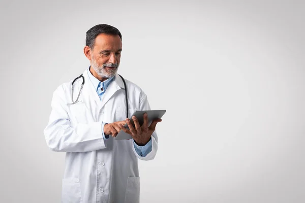 Happy Caucasian Mature Man Doctor White Coat Typing Tablet Isolated — Stock Photo, Image