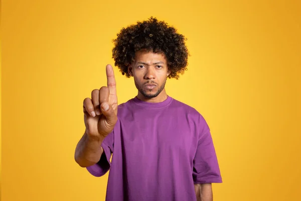 紫のTシャツの深刻な怒りの黒の大人の巻き男を自信を持って指を表示し サインを停止し オレンジの背景 スタジオに孤立した 沈黙とジェスチャー 広告や提供しません — ストック写真