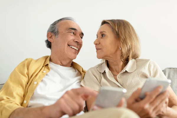 Modern Senior Spouses Sitting Couch Using Smartphones Sharing Photos Social — Stock Photo, Image