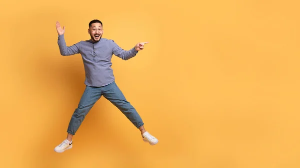 Positiv Ung Asiatisk Man Visar Kopiera Utrymme Medan Hoppa Luften — Stockfoto