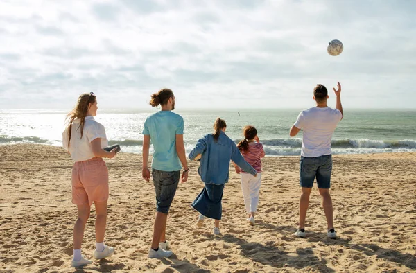 Stock image Cheerful millennial multiracial people in casual play at ball, have fun together, enjoy freedom, game on beach at weekend, outdoor. Active lifestyle with friends, holidays and walk