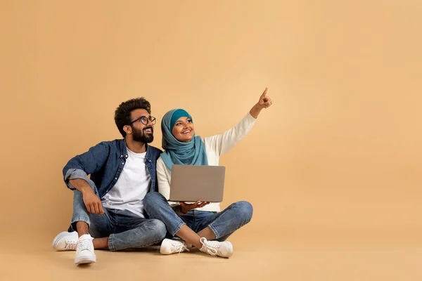 Online Nabídka Usmívající Muslim Pár Notebookem Počítač Ukazující Pryč Kopírovat — Stock fotografie