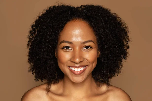 明るい魅力的な半裸の若いアフリカ系アメリカ人女性のクローズアップ肖像画 忙しい髪 完璧な輝く肌の色のスタジオの背景にポーズをとって カメラで笑顔 スキンケアコンセプト — ストック写真