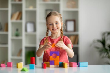 Gelişim faaliyetleri. Şirin Mutlu Küçük Kız Renkli Tahta Tuğlalarla Oynuyor, Mutlu Kadın Çocuk Parlak Bloklar Piramidi, Neşeli Çocuk Masa Oyunları, Kopya Boşluğu