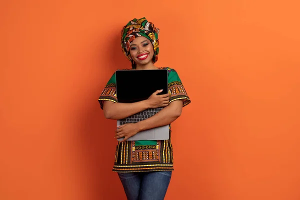 Ekscytująca Młoda Ładna Czarna Kobieta Afrykańskim Kostiumie Obejmująca Nowoczesny Laptop — Zdjęcie stockowe