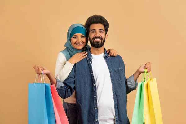 Nöjda Kunder Porträtt Unga Muslimska Par Med Shoppingväskor Posing Beige — Stockfoto