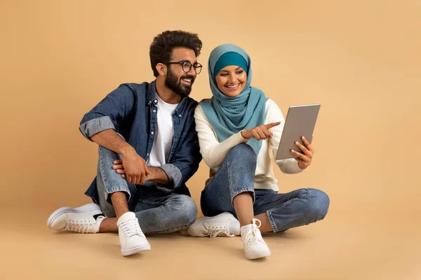 Feliz Joven Pareja Árabe Usando Tableta Digital Mientras Está Sentado —  Fotos de Stock