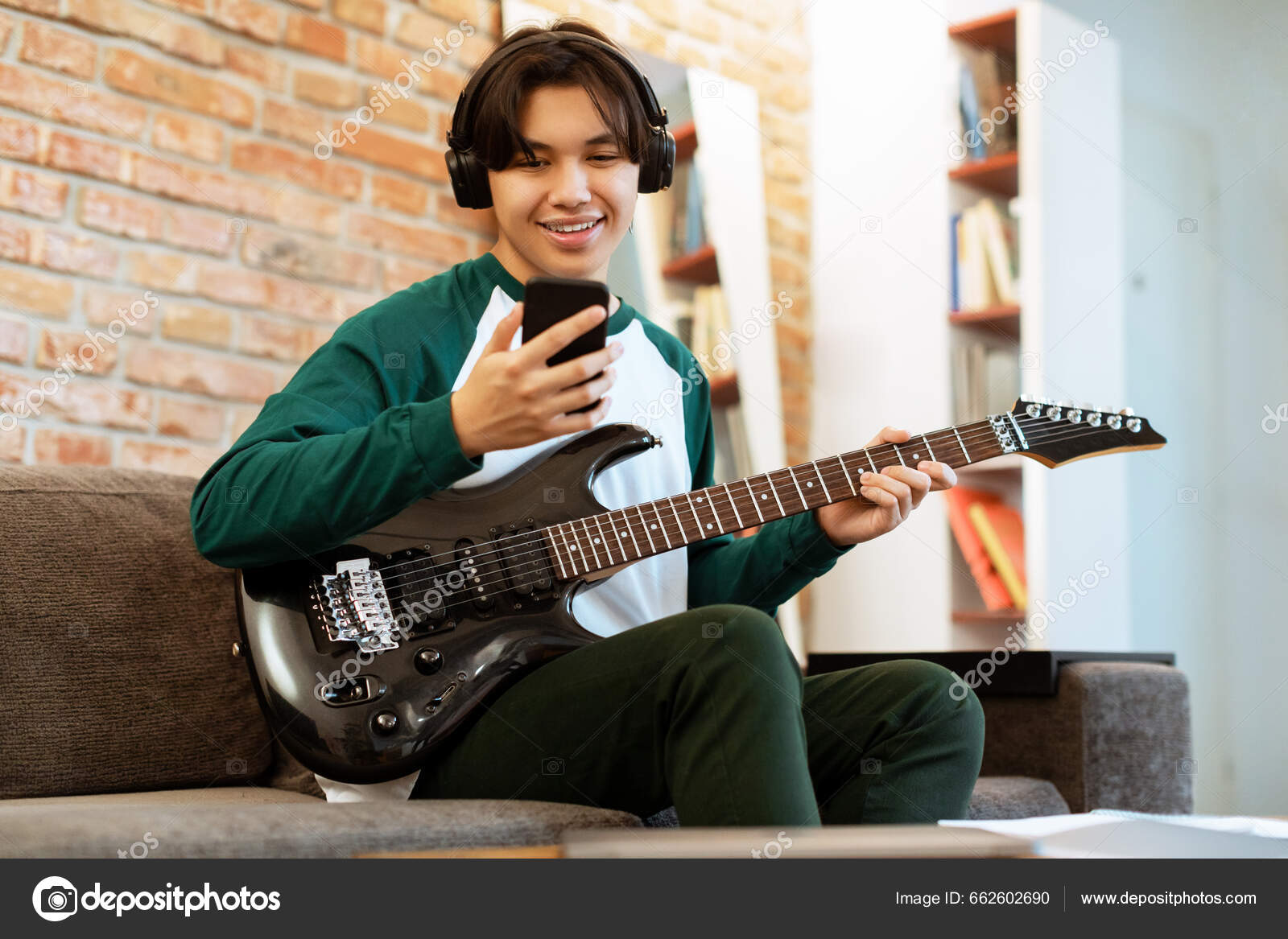 lazy teenager boy play computer games, sit in headphones, looking at screen  of laptop, free time at home Stock Photo