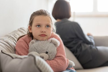 Oyuncaklı mutsuz genç kız oturma odasının içinde bin yıllık beyaz bir kadını görmezden geliyor, kapat. Tartışma, aile, ilişki sorunları, evde stres ve ebeveynlik