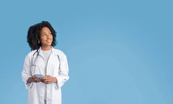 Fröhliche Junge Afrikanisch Amerikanische Lockige Ärztin Weißem Mantel Benutzt Telefon — Stockfoto