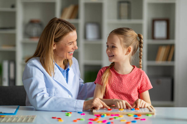 Psychotherapist Lady Having Session Meeting With Cute Little Girl, Child Development Specialist Exercising With Smiling Female Kid, Making Words Of Colorful Letters Together, Closeup