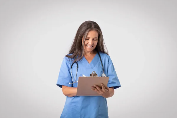 Glückliche Ärztin Die Die Krankengeschichte Ihrer Patienten Überprüft Und Notizen — Stockfoto