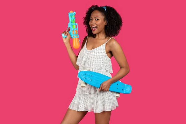 Счастливая Молодая Черная Кудрявая Дама Открытым Ртом Скейтбордом Водяным Пистолетом — стоковое фото