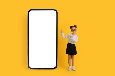 Güzel uygulama. Beyaz Ekranlı Büyük Boş Akıllı Telefonu işaret eden şirin liseli kız, Mobil Reklam Tasarımı, Kolajı, Mobil Tasarımı için Kopya Alanı Gösteren Gözlüklü Küçük Kız Çocuk,