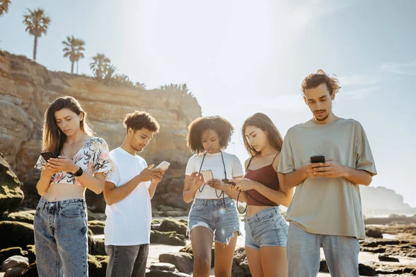 夏休みには数百万人の黒人 アジア人 アラブ人 ヨーロッパ人の学生がビーチでスマートフォンでチャットをしています ブログ ソーシャルネットワークアプリ 週末の問題 旅行のオンラインマップ — ストック写真