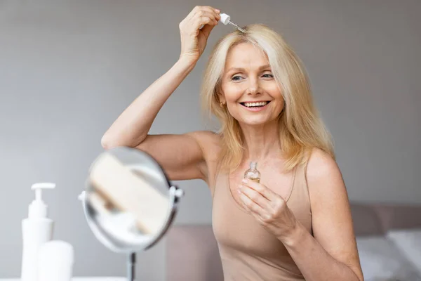 Glücklich Gealterte Frau Die Serum Zur Haarreparatur Anwendet Spiegel Anschaut — Stockfoto