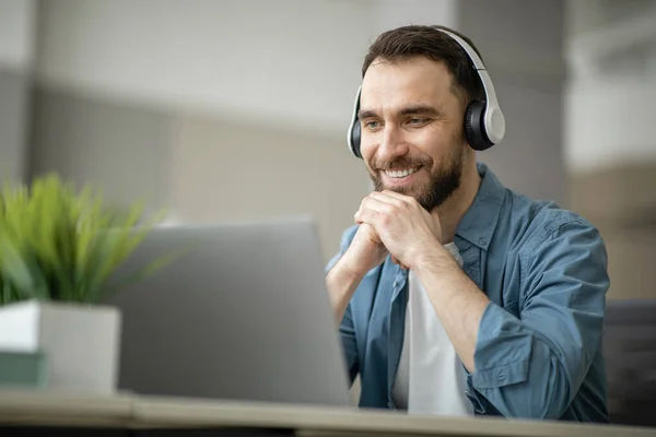 Kablosuz Kulaklıklı Gülümseyen Genç Adam Dizüstü Bilgisayarda Giyiniyor Mutlu Bir — Stok fotoğraf