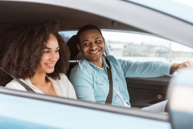 Otomobil yolculuğu. Yeni arabasında oturan genç Arap erkek ve kadını seven, yaz tatilinde kırsala giden, şoförün karısına gülümsemesi. Seçici odaklanma, kenar görünüm çekimi