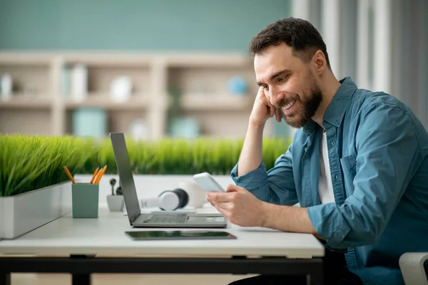 Χαμογελώντας Αρσενικό Υπάλληλο Χρησιμοποιώντας Smartphone Στο Χώρο Εργασίας Στο Γραφείο — Φωτογραφία Αρχείου