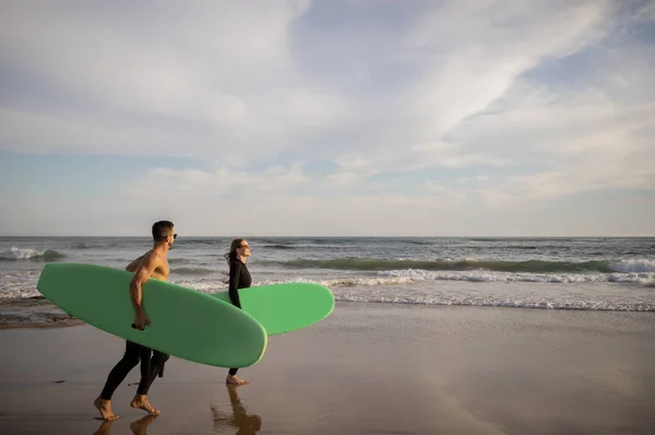Zajęcia Letnie Szczęśliwa Młoda Para Nosząca Deski Surfingowe Spacerując Wzdłuż — Zdjęcie stockowe