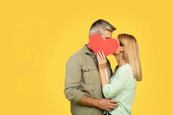 Namorados Meia Idade Escondidos Atrás Coração Papel Vermelho Beijando Cobrindo — Fotografia de Stock